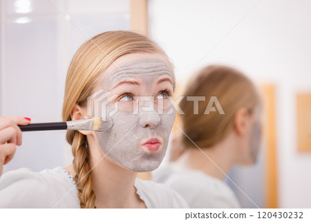 Woman with grey clay mud mask on her face Woman with grey clay mud mask on her face 120430232