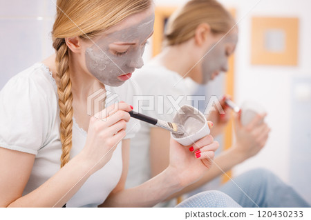 Woman with grey clay mud mask on her face 120430233
