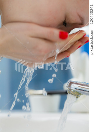 Woman washing face in bathroom. Hygiene. Woman washing face in bathroom. Hygiene. 120430241