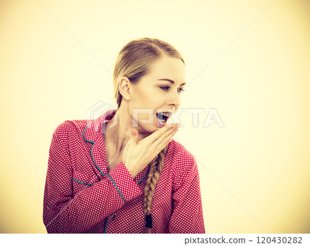 Sleepy young woman wearing cute pink pajamas Sleepy young woman wearing cute pink pajamas 120430282