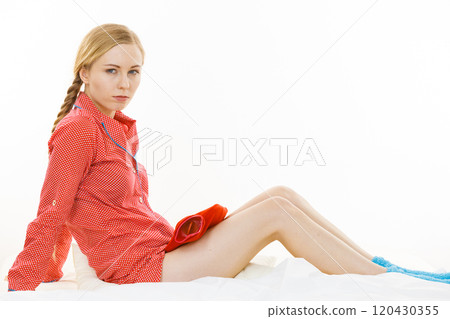 Woman holding warm red hot water bottle 120430355