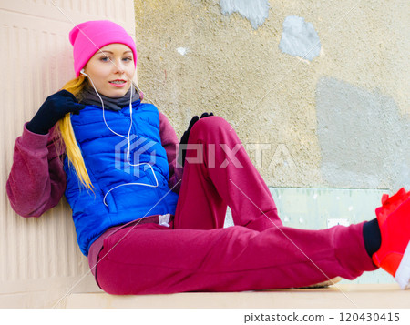Woman wearing warm sportswear relaxing after exercising 120430415