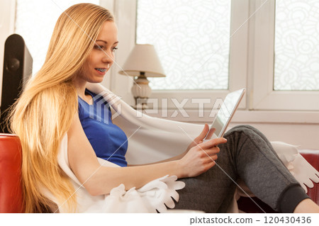 Young woman relaxing with tablet 120430436