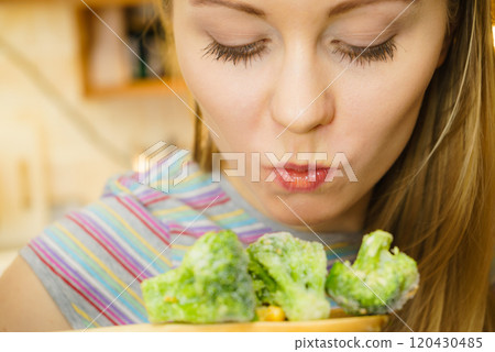 Woman tasting stir fry vegetable from pan Woman tasting stir fry vegetable from pan 120430485