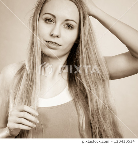Young woman touching her long hair Young woman touching her long hair 120430534