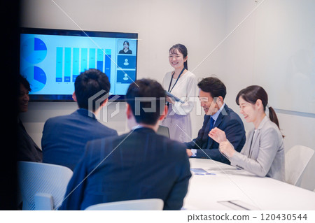 Young woman giving a presentation in a conference room 120430544