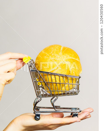 Hand holding shopping cart with bread Hand holding shopping cart with bread 120430560