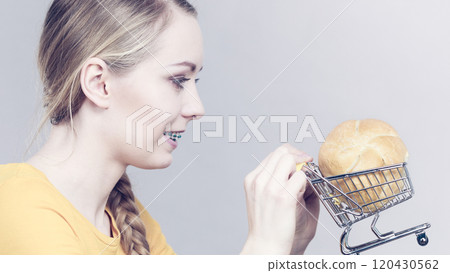 Woman holding shopping cart with bread Woman holding shopping cart with bread 120430562