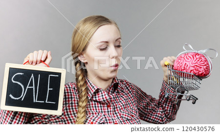 Woman holding shopping cart with brain Woman holding shopping cart with brain 120430576