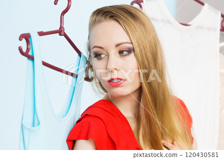 Woman in shop or wardrobe picking dress Woman in shop or wardrobe picking dress 120430581