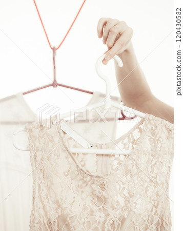 Woman in shop or wardrobe picking dress Woman in shop or wardrobe picking dress 120430582