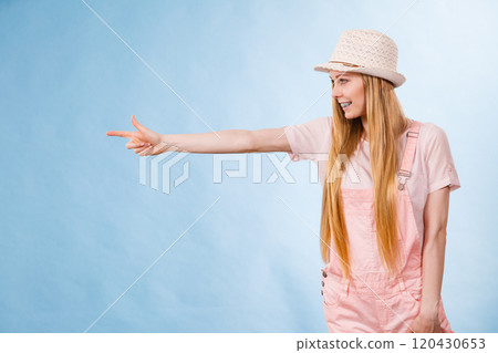 Woman wearing summer outfit pointing 120430653