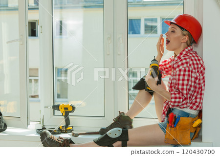 Bored woman with helmet next to the window Bored woman with helmet next to the window 120430700