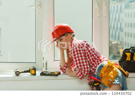 Woman with helmet next to the window 120430702