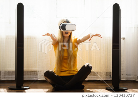 Girl wearing virtual reality goggles at home Girl wearing virtual reality goggles at home 120430727