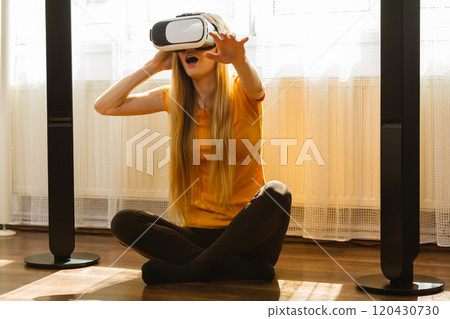 Girl wearing virtual reality goggles at home Girl wearing virtual reality goggles at home 120430730