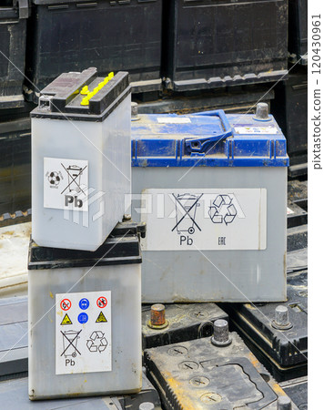 Stack of many used car batteries for recycling in a hazardous waste facility 120430961