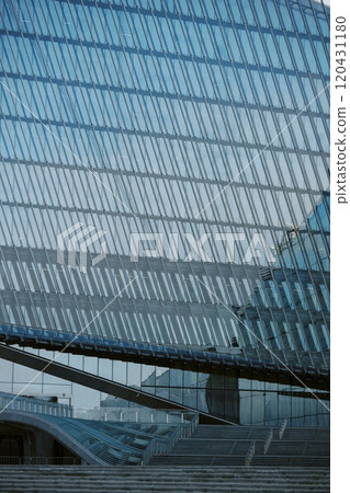 Showcasing innovative architectural design featuring large glass facades and steel structures reflecting contemporary urban setting. Emphasizing clean lines and geometric patterns Showcasing innovative architectural design featuring large glass facades and steel structures reflecting contemporary urban setting. Emphasizing clean lines and geometric patterns 120431180