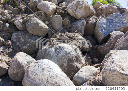 A large, uneven pile of rocks is precariously sitting on top of each other A large, uneven pile of rocks is precariously sitting on top of each other 120431203