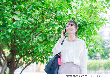 Young woman making a phone call outside Young woman making a phone call outside 120431388