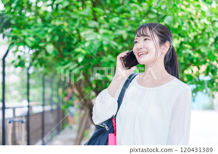 Young woman making a phone call outside Young woman making a phone call outside 120431389