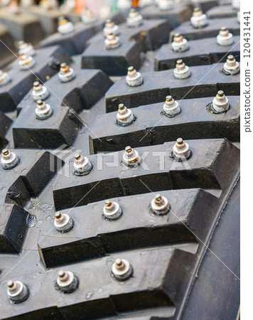 Closeup of the tread of a studded snow and ice tire with large studs for winter rally use only 120431441