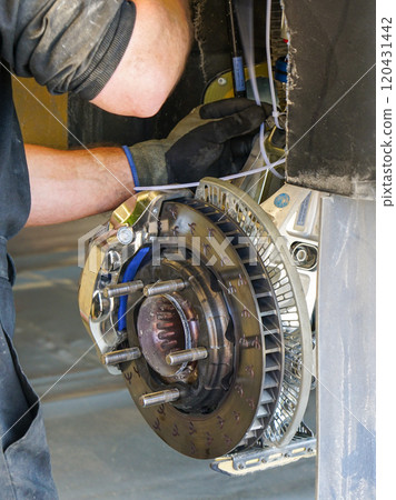 High performance rally car rear suspension and brake system maintenance works at rally service park High performance rally car rear suspension and brake system maintenance works at rally service park 120431442