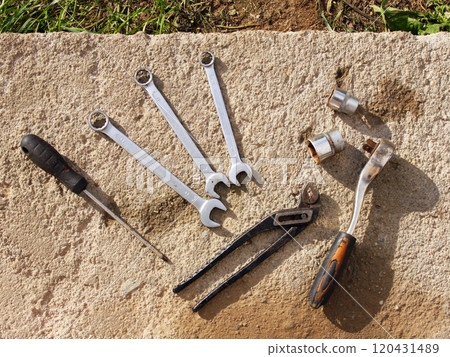 A set of old tools: wrenches, ratchet, screwdrivers, pliers, cap wrenches on a concrete surface background. Automotive repair, mechanics, car restoration, work and industry A set of old tools: wrenches, ratchet, screwdrivers, pliers, cap wrenches on a concrete surface background. Automotive repair, mechanics, car restoration, work and industry 120431489