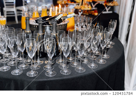 Luxury event setup with champagne bottles, flutes, and orange juice on a banquet table 120431784