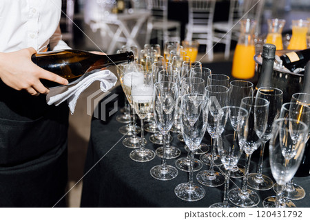 Elegant champagne pouring at a formal event with glasses prepared for celebration 120431792