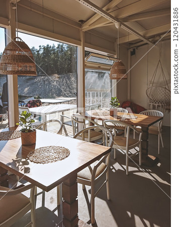 Cozy beach cafe near water cable park in boho style with vintage furniture and hammock chair 120431886