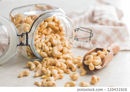 Roasted cashew nuts in jar on kitchen table. 120431928