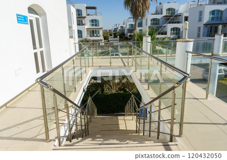 Exploring the vibrant terrace staircase leading into a lush garden at a modern coastal villa. 120432050