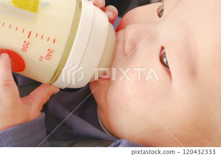 Asian baby drinking milk from a baby bottle Asian baby drinking milk from a baby bottle 120432333
