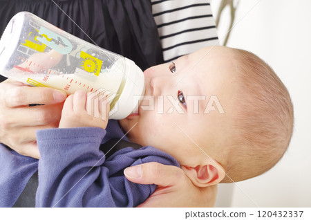 Asian baby drinking milk from a baby bottle Asian baby drinking milk from a baby bottle 120432337