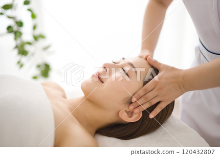 Woman receiving a massage from an esthetician 120432807