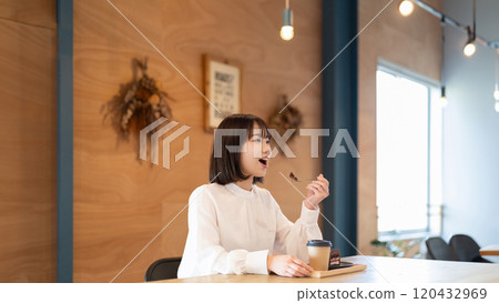 Young woman eating sweets at a cafe Young woman eating sweets at a cafe 120432969