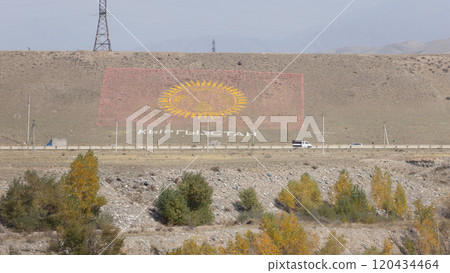 the flag of Kyrgyzstan on the hill, built by stone and sand near issyk-kul region the flag of Kyrgyzstan on the hill, built by stone and sand near issyk-kul region 120434464