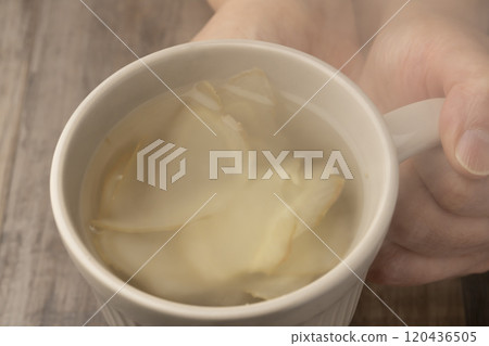 手裡拿著一個裝滿薑茶的杯子 120436505