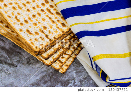 Matzah unleavened bread rests alongside striped towel, symbolizing Jewish traditions during Passover of preparations for holiday. Matzah unleavened bread rests alongside striped towel, symbolizing Jewish traditions during Passover of preparations for holiday. 120437751