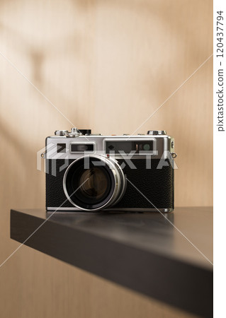 A vintage film camera sits elegantly on a table, showcasing timeless craftsmanship. A vintage film camera sits elegantly on a table, showcasing timeless craftsmanship. 120437794