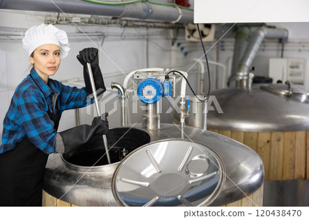 Woman brewmaster mixing beer in tank Woman brewmaster mixing beer in tank 120438470