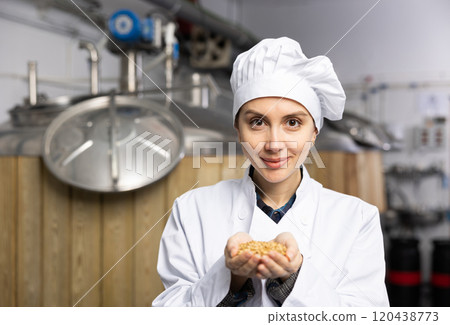 Portrait of woman brewmaster holding bunch of malt seeds 120438773
