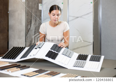 Young woman choosing sample of house siding Young woman choosing sample of house siding 120438801