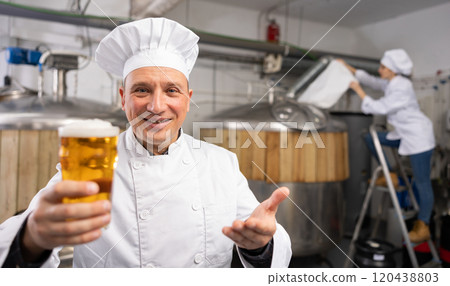Happy brewery owner inviting to tasting amber beer Happy brewery owner inviting to tasting amber beer 120438803