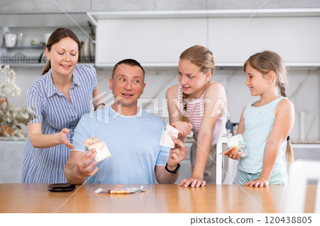 Man gives his smiling wife and daughter money for ladie' nice little things, trinkets 120438805