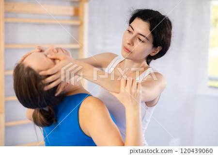 Two women training self-defense techniques in studio 120439060
