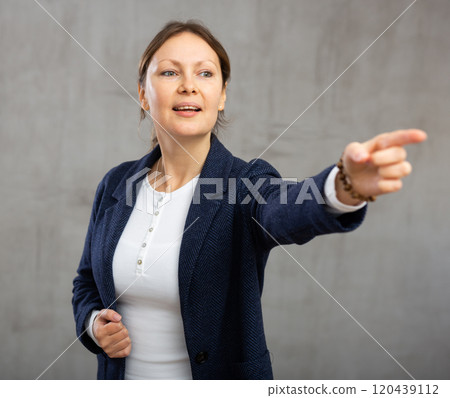 Cheerful woman with wide grin on her face exuding happiness and positivity pointing Cheerful woman with wide grin on her face exuding happiness and positivity pointing 120439112