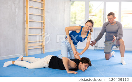Woman learns to make power grab against male attacker under guidance of trainer. Self-defense class 120439113