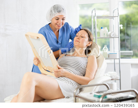 Young woman cosmetologists examines face of female patient 120439165